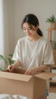© imak - Young Woman Sitting on Bed Unpacking Cardboard Box at Home