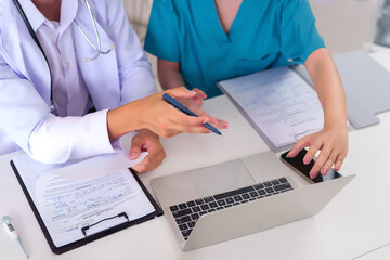 Wall Mural - Doctors Discussing Patient Information on Laptop Asian Medical Team Examines Health Records and Planning Treatment at Clinic or Hospital Healthcare Professionals Collaboration