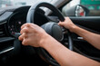 © Suthida - Close-up of hands on steering wheel while driving