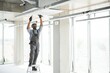 © Serhii - African American electrician repairing air conditioner indoors