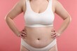 © New Africa - Weight loss. Plus size woman in underwear on pink background, closeup