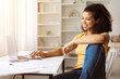 © Anastasiya - Cheerful Young Black Woman Using Laptop And Sitting In Relaxed Pose At Desk At Home, Happy African American Female Chilling In Internet, Surfing Online, Resting Indoors With Computer