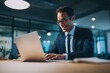 © ttonaorh - A smiling businessman working on a laptop in a modern office with natural lighting and soft colors, and a minimalistic office background.