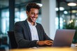 © ttonaorh - Young smiling businessman working on a laptop in the office.