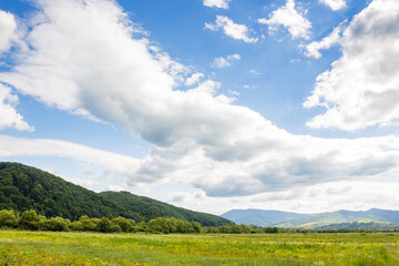countryside landscape with field near the hill. cloudscape above natural wide pasture. beautiful nat