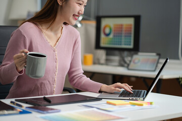 female coder or developer working using a smartphone and computer display in problem solving at work