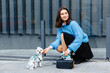 © nazariykarkhut - Young woman petting her dog in the city