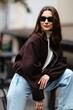 © nazariykarkhut - Fashionable woman wearing sunglasses and posing in urban setting