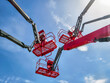 © OlegDoroshin - Workers operating lift equipment under clear blue sky during outdoor construction activity near urban area
