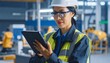 © Muhammad - Female Engineer using Tablet in Factory.