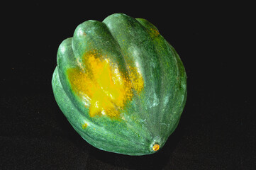 top view, close distance of, a ripe acorn squash, on black background