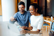 © (JLco) Julia Amaral - Two professionals at a desk using a laptop in a bright office setting