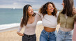 © PintoArt - Three happy young women walking on beach, enjoying sunny day