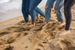 © PintoArt - Friends wearing jeans are enjoying walking barefoot on the beach