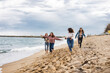 © PintoArt - Four young women running on the beach, enjoying freedom and friendship