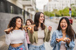 © PintoArt - Cheerful young women eating pizza and walking down the street