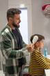 © Antonio Recena - 40 years old Father combing his son's hair in the bathroom of their home