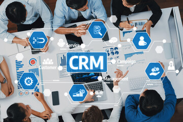 Poster - Diverse business team engaged in collaborative CRM strategy discussion with data-driven visuals and charts in a modern office setting. Focus on teamwork and productivity. Amity