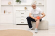 © New Africa - Senior man suffering from pain in knee at home