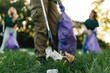 © Zamrznuti tonovi - Group of people picking up trash in park with grabber tool