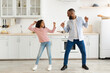 © Prostock-studio - Playful Mood. Excited African American father and joyful girl dancing while cooking together at kitchen, fooling around, cheerful man holding whisk, spending free time with cute daughter