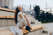 © SHOTPRIME STUDIO - Confident businesswoman seated outdoors, showcasing modern style and serene emotions in a contemporary urban setting, emphasizing professionalism and elegance.