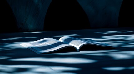 Wall Mural - religious book is open on a table, with a shadow cast on the table from the sunlight. the book is a 