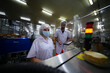 © FotoArtist - Workers in food processing facility inspect machines while practicing safety protocols