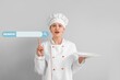 © Pixel-Shot - Female chef pointing at web search engine against grey background