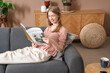 © Pixel-Shot - Young pretty woman reading magazine on sofa in stylish living room