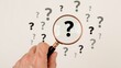 © Maxpoint Imran - Magnifying Glass Focuses on Question Marks Amidst Uncertainty and Searching for Answers hand