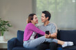 © Crystal - Happy asian couple is spending time together on the sofa, browsing social media and enjoying their free time