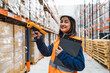 © Koldo_Studio - Smiling warehouse worker scanning packages with a barcode scanner while efficiently managing inventory in a busy logistics center