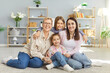 © Studio Romantic - Happy family together, grandchildren, mother and grandmother friendly portrait at home, sit laughing on floor, hugging with love, warmth, care, enjoying family relations, communication and close care