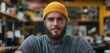 © BlackBird Studio - Confident Young Man with Beard and Tattoos Wearing Yellow Beanie in Cozy Urban Cafe