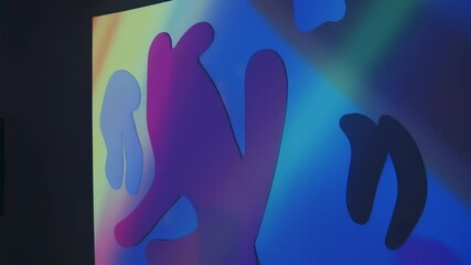 Wall Mural - colorful abstract shapes changing colors on a wall in dark room background animation
