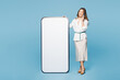 © ViDi Studio - Full body young happy employee business woman corporate lawyer wear shirt classic formal clothes work in office big huge blank screen talk speak on mobile cell phone isolated on plain blue background.