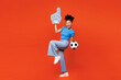 © ViDi Studio - Full body young woman fan she wear blue t-shirt foam 1 glove finger up cheer up support football sport team hold soccer ball watch tv live stream raise up leg isolated on plain red orange background.