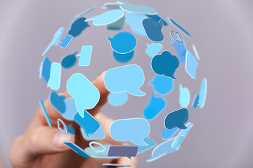 Aufkleber - Abstract image of a hand interacting with a sphere of blue speech bubbles, representing global communication and social media.