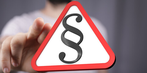 Aufkleber - Hand pointing at a red triangle warning sign with a paragraph symbol.  Legal concept.