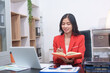 © Worapon - Cheerful business lady working on laptop in office, Asian happy beautiful businesswoman in formal suit work in workplace. Attractive female employee office worker smile.