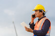 © manit - Construction Worker Communicating with Walkie-Talkie, On-Site Supervisor with Two-Way Radio and Safety Gear, Engineer or Foreman Listening to Instructions at Construction Site