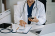 © NINENII - Doctor physician with stethoscope calculate medical fee costs or revenue. practitioner use calculator at Clinic.