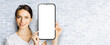 © vgstudio - Portrait image - happy smile cute businesswoman business woman show point big mockup cell phone, smartphone mobile cellphone with white screen. Online offer ad. Free text space. Bricks wall background