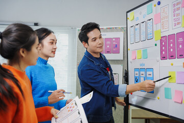 web designers team brainstorming mobile application ui design on whiteboard, discussing user experie