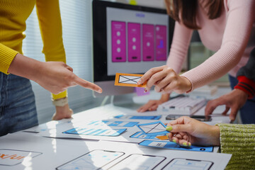 Web designers team planning application development for web and mobile phone using design guideline, design mockup, and prototype