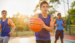 © Anna K@S - Teenagers playing basketball on a sunny court