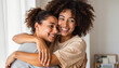 © Anna K@S - Two smiling women embracing joyfully in a cozy indoor setting