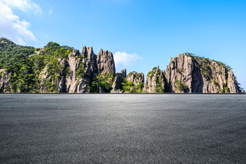 Wall Mural - empty asphalt platform and rocky mountain with green trees under blue sky in huangshan, anhui, china