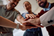 © Drazen - Close up of business team gathering hands in unity.